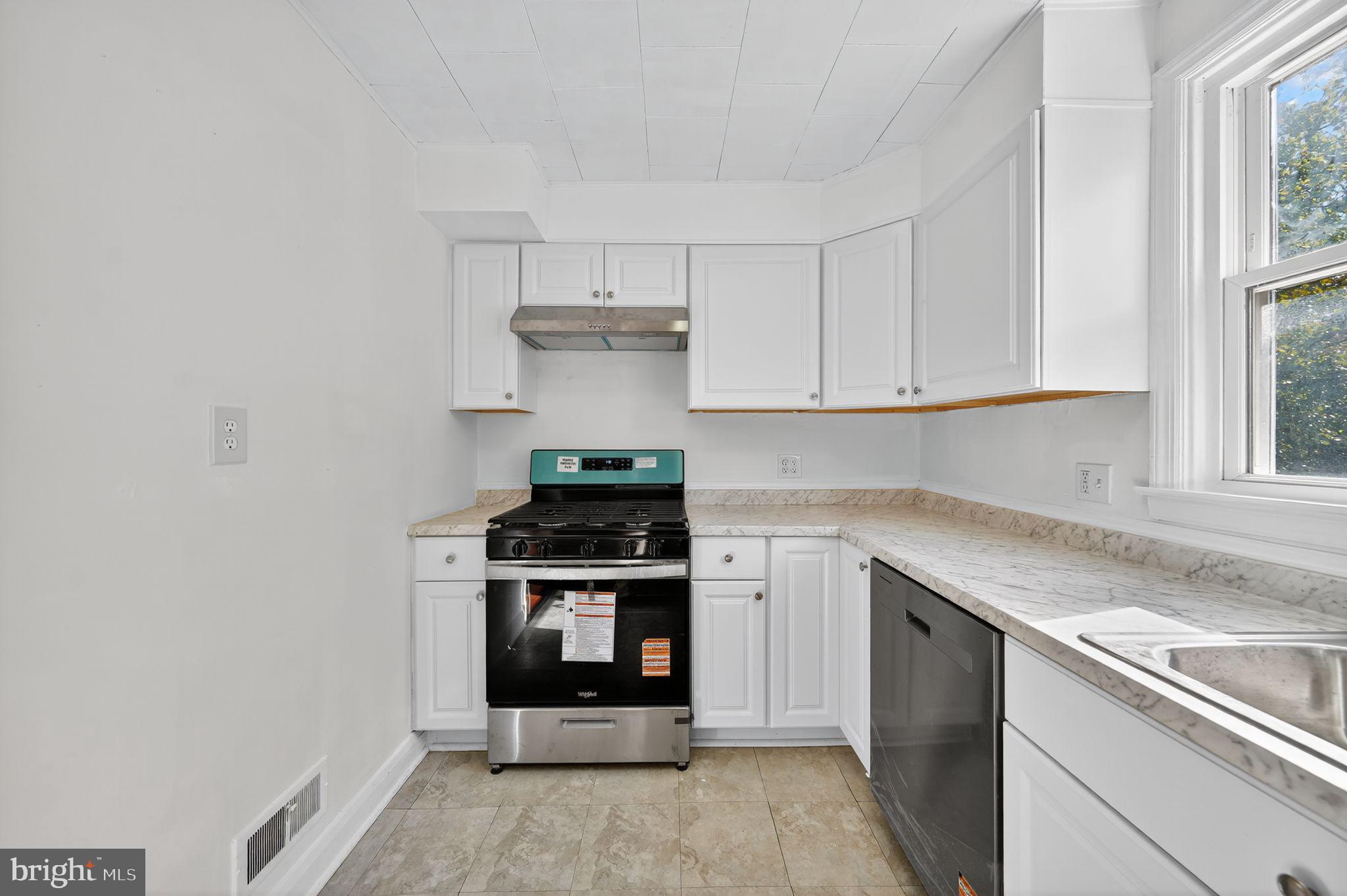 4401 Ridge Drive Baltimore, MD 21229 - Photo 16 of 30 a kitchen with stainless steel appliances granite countertop a stove and a white cabinets