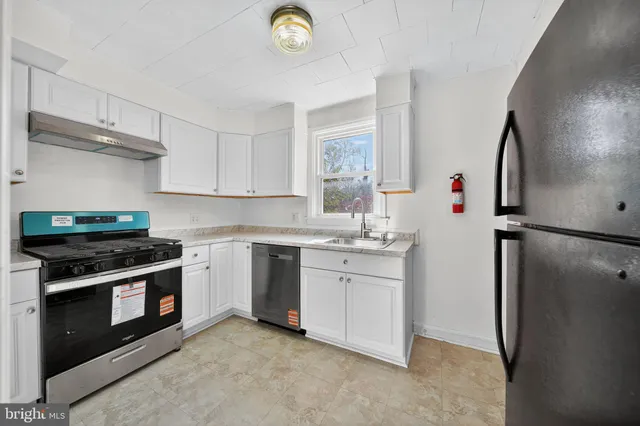 a kitchen with stainless steel appliances granite countertop a stove a refrigerator and a sink