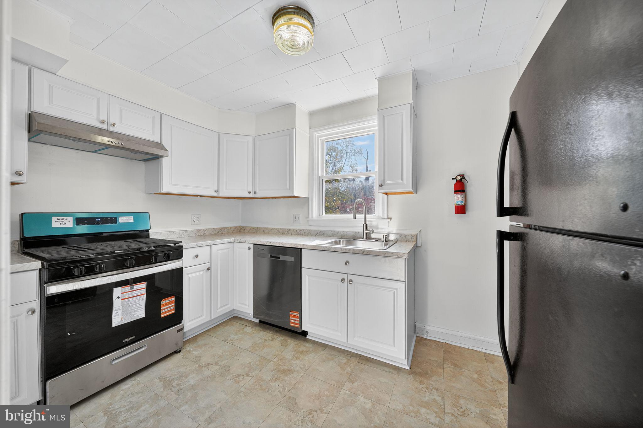4401 Ridge Drive Baltimore, MD 21229 - Photo 17 of 30 a kitchen with stainless steel appliances granite countertop a stove a refrigerator and a sink