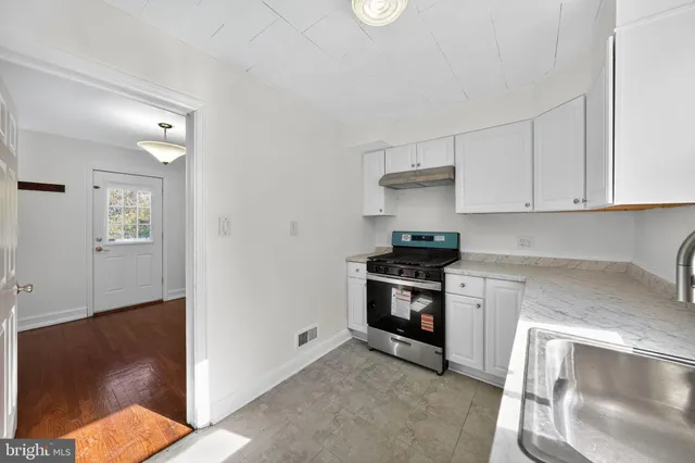 a kitchen with granite countertop white cabinets and stainless steel appliances