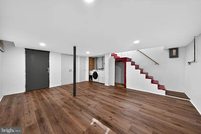 a view of a livingroom with wooden floor and staircase