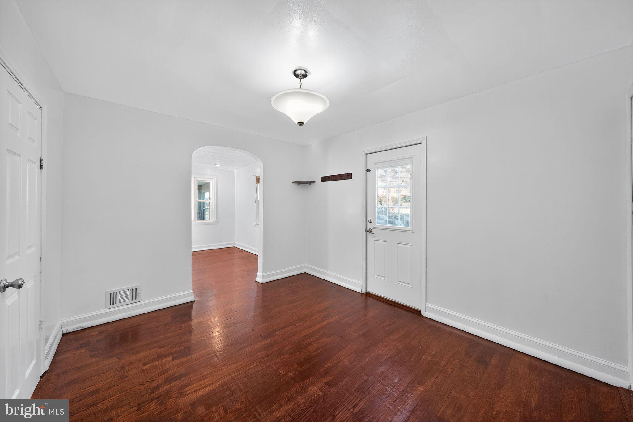 4401 Ridge Drive Baltimore, MD 21229 - Photo 6 of 30 an empty room with wooden floor chandelier and windows