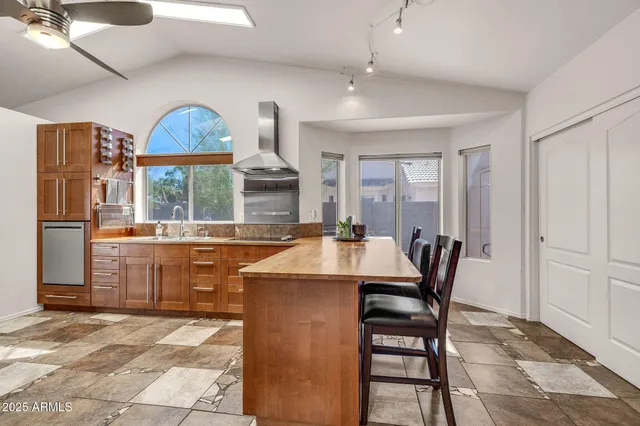 a large white kitchen with stainless steel appliances granite countertop a refrigerator and a sink