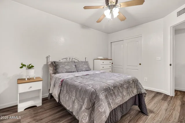 a living room with a bed and ceiling fan