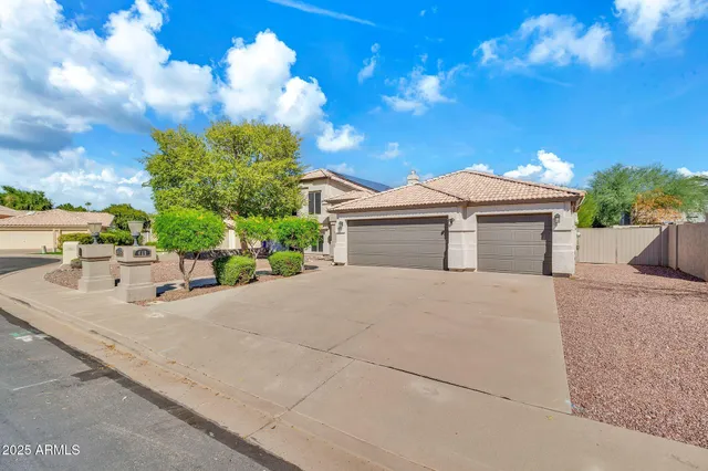 a view of a house with a yard and large tree
