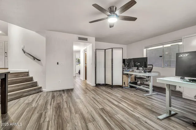 a view of a livingroom with wooden floor and a fireplace