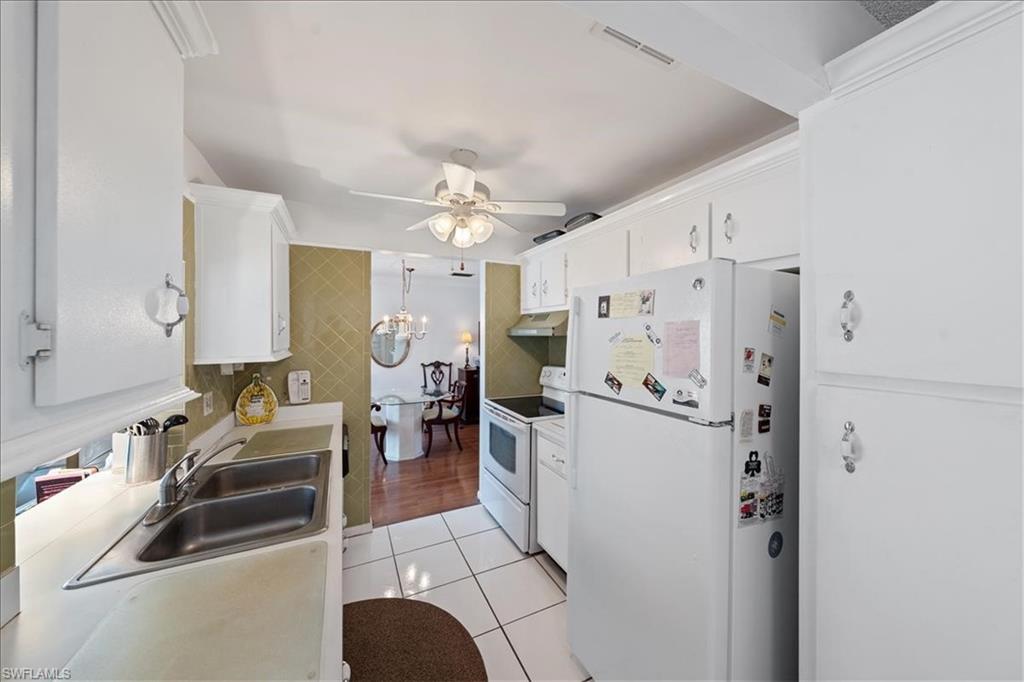 1069 Forest Lakes Drive, Unit 1B Naples, FL 34105 - Photo 13 of 29 a kitchen with stainless steel appliances a refrigerator sink and cabinets