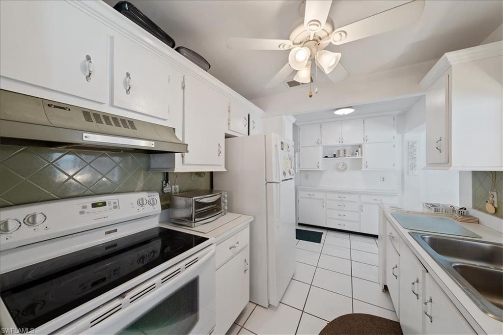 1069 Forest Lakes Drive, Unit 1B Naples, FL 34105 - Photo 15 of 29 a kitchen with a stove a sink and a refrigerator