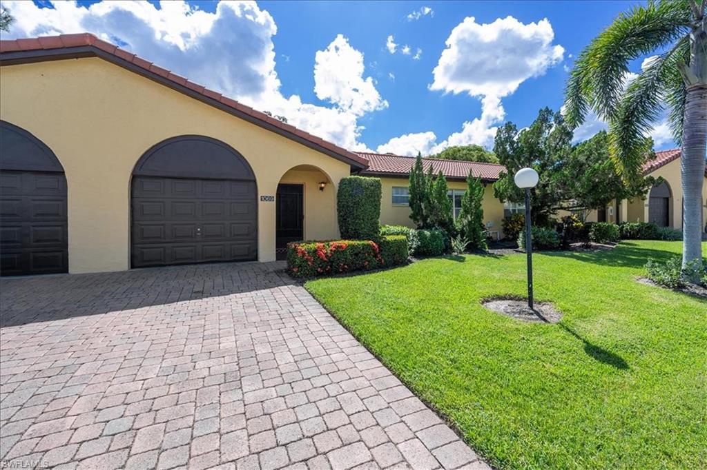 1069 Forest Lakes Drive, Unit 1B Naples, FL 34105 - Photo 2 of 29 a front view of a house with a yard and garage