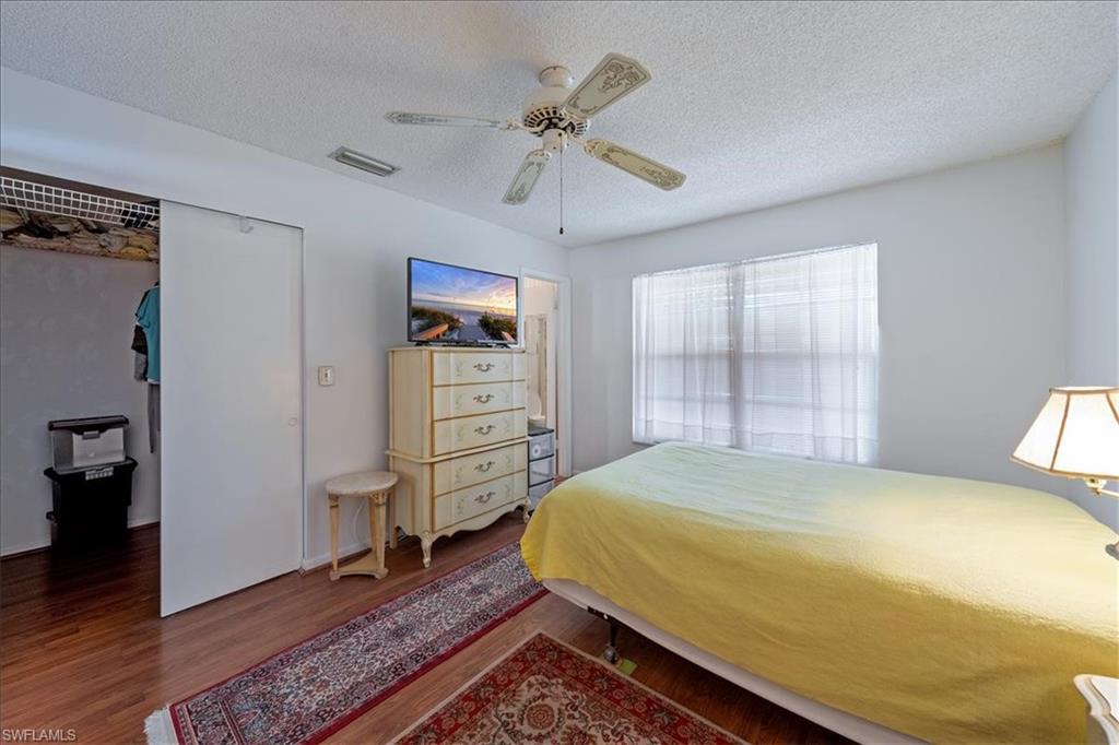 1069 Forest Lakes Drive, Unit 1B Naples, FL 34105 - Photo 21 of 29 a bedroom with a bed and a chandelier