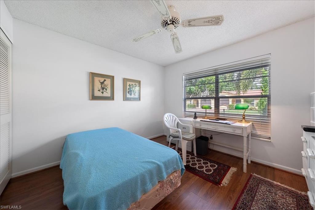 1069 Forest Lakes Drive, Unit 1B Naples, FL 34105 - Photo 22 of 29 a bedroom that has a bed and a table in it