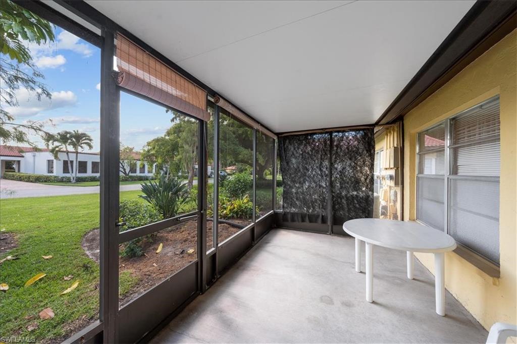 1069 Forest Lakes Drive, Unit 1B Naples, FL 34105 - Photo 25 of 29 a living room with a large window and table