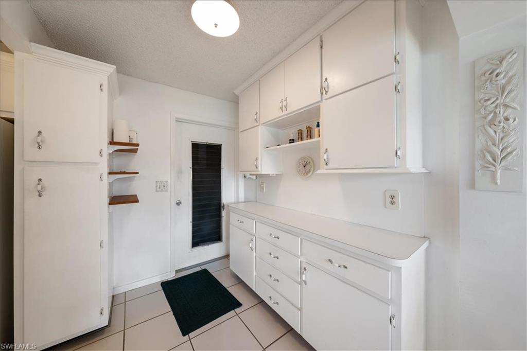 1069 Forest Lakes Drive, Unit 1B Naples, FL 34105 - Photo 26 of 29 a kitchen with white cabinets and refrigerator