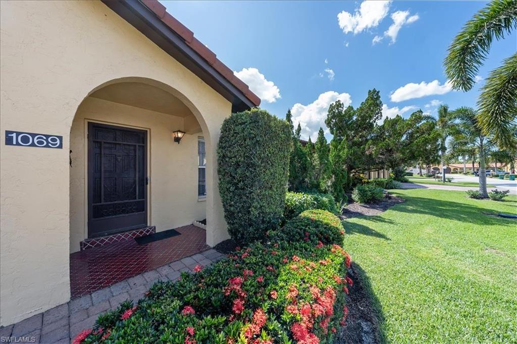 1069 Forest Lakes Drive, Unit 1B Naples, FL 34105 - Photo 3 of 29 a front view of a house with a yard