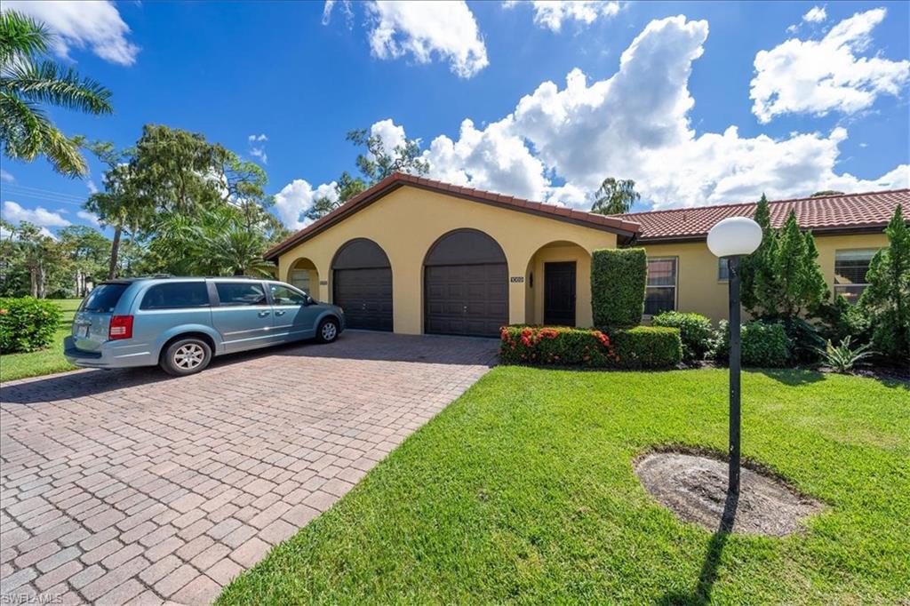 1069 Forest Lakes Drive, Unit 1B Naples, FL 34105 - Photo 4 of 29 a front view of a house with a garden
