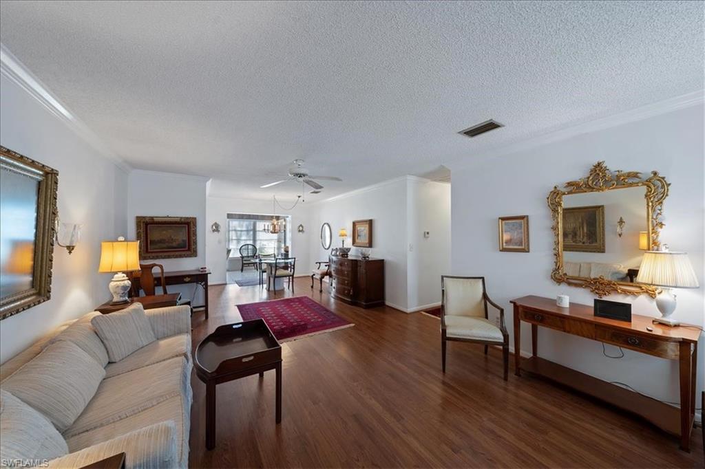 1069 Forest Lakes Drive, Unit 1B Naples, FL 34105 - Photo 9 of 29 a living room with furniture flat screen tv and wooden floor