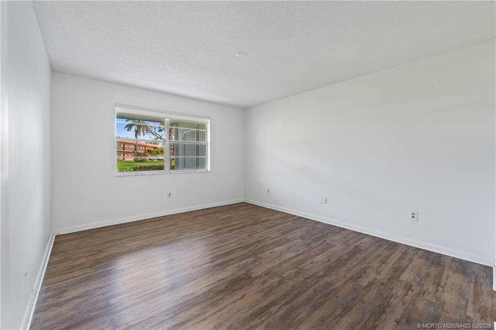 1903 Southwest Palm City Road, Unit C Stuart, FL 34994 - Photo 30 of 34 an empty room with wooden floor and windows