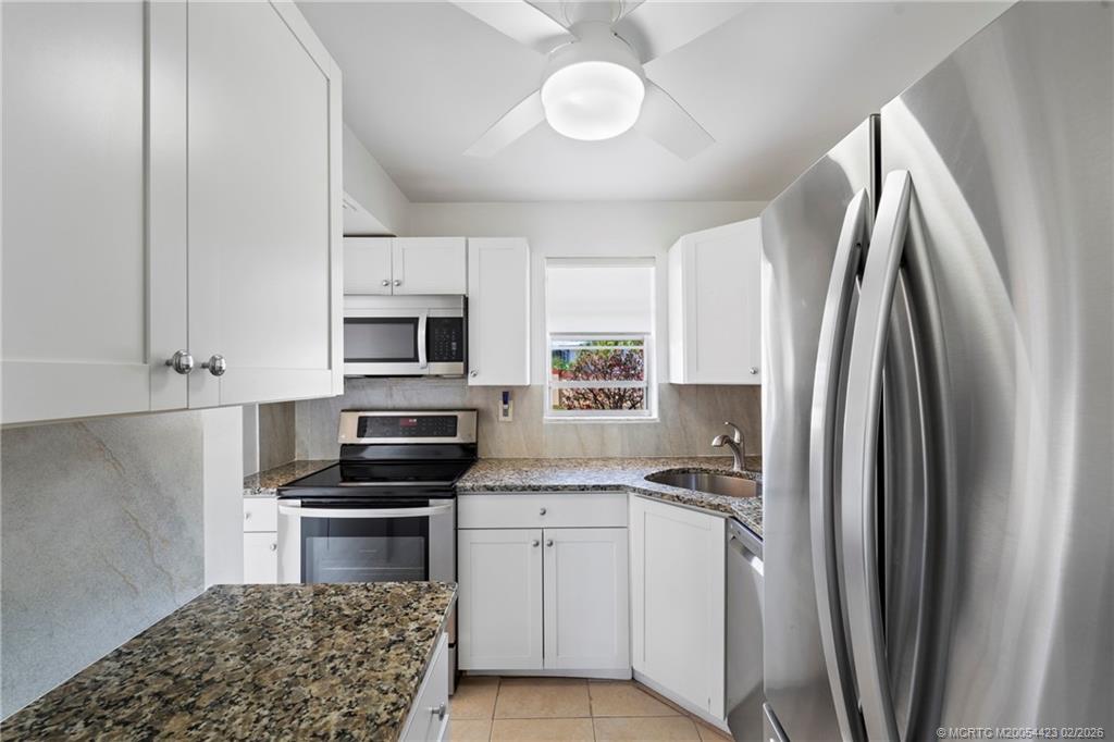 1903 Southwest Palm City Road, Unit C Stuart, FL 34994 - Photo 6 of 34 a kitchen with stainless steel appliances a refrigerator sink and microwave