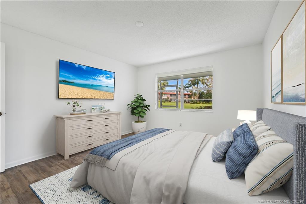 1903 Southwest Palm City Road, Unit C Stuart, FL 34994 - Photo 8 of 34 a bedroom with a bed and a flat screen tv