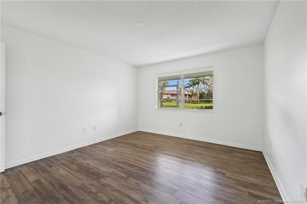 1903 Southwest Palm City Road, Unit C Stuart, FL 34994 - Photo 9 of 34 an empty room with wooden floor and window