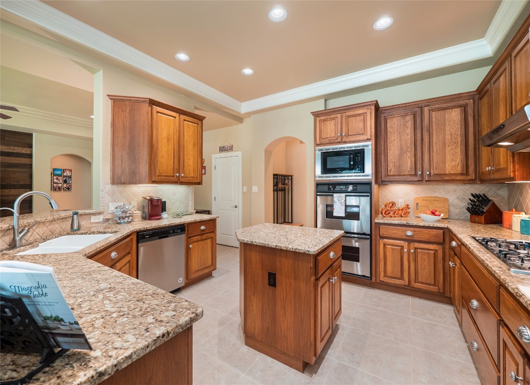 104 East Rustle Cove Georgetown, TX 78628 - Photo 12 of 40 a kitchen with stainless steel appliances granite countertop wooden cabinets sink and stove