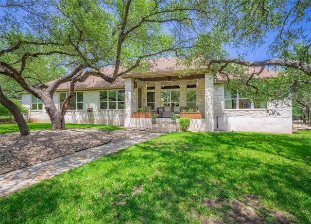 a backyard of a house with a yard and outdoor seating