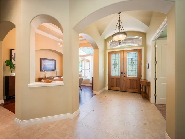 a view of a hallway with entryway dining room and chandelier