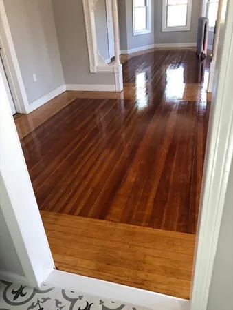 a view of empty room with wooden floor