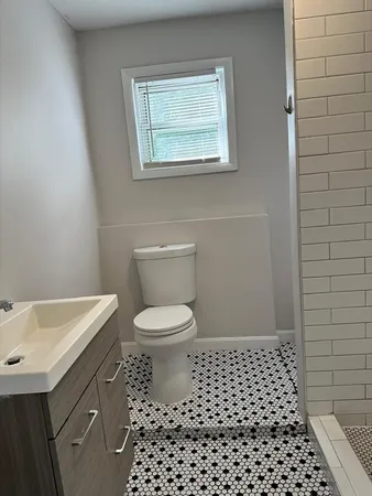 a bathroom with a toilet a sink and a window