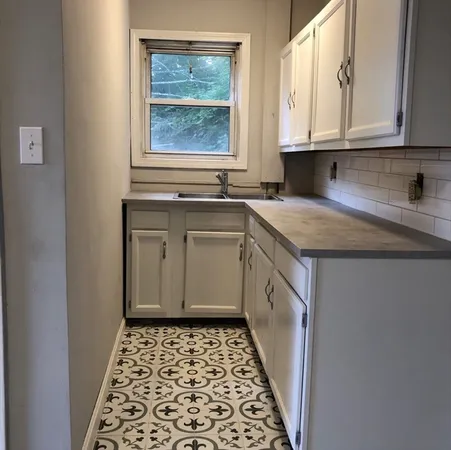 a kitchen with a sink stove and cabinets