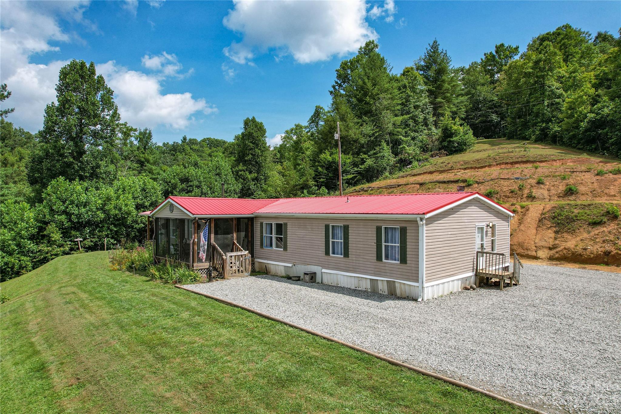 3113 Revere Road Marshall, NC 28753 - Photo 19 of 47 a view of a white house with a big yard and table and chairs under an umbrella