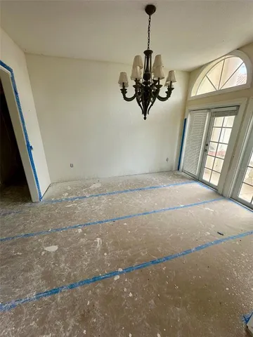 a view of a room with a large window a ceiling fan and windows