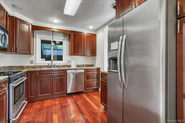 a kitchen with stainless steel appliances granite countertop a refrigerator and a stove top oven
