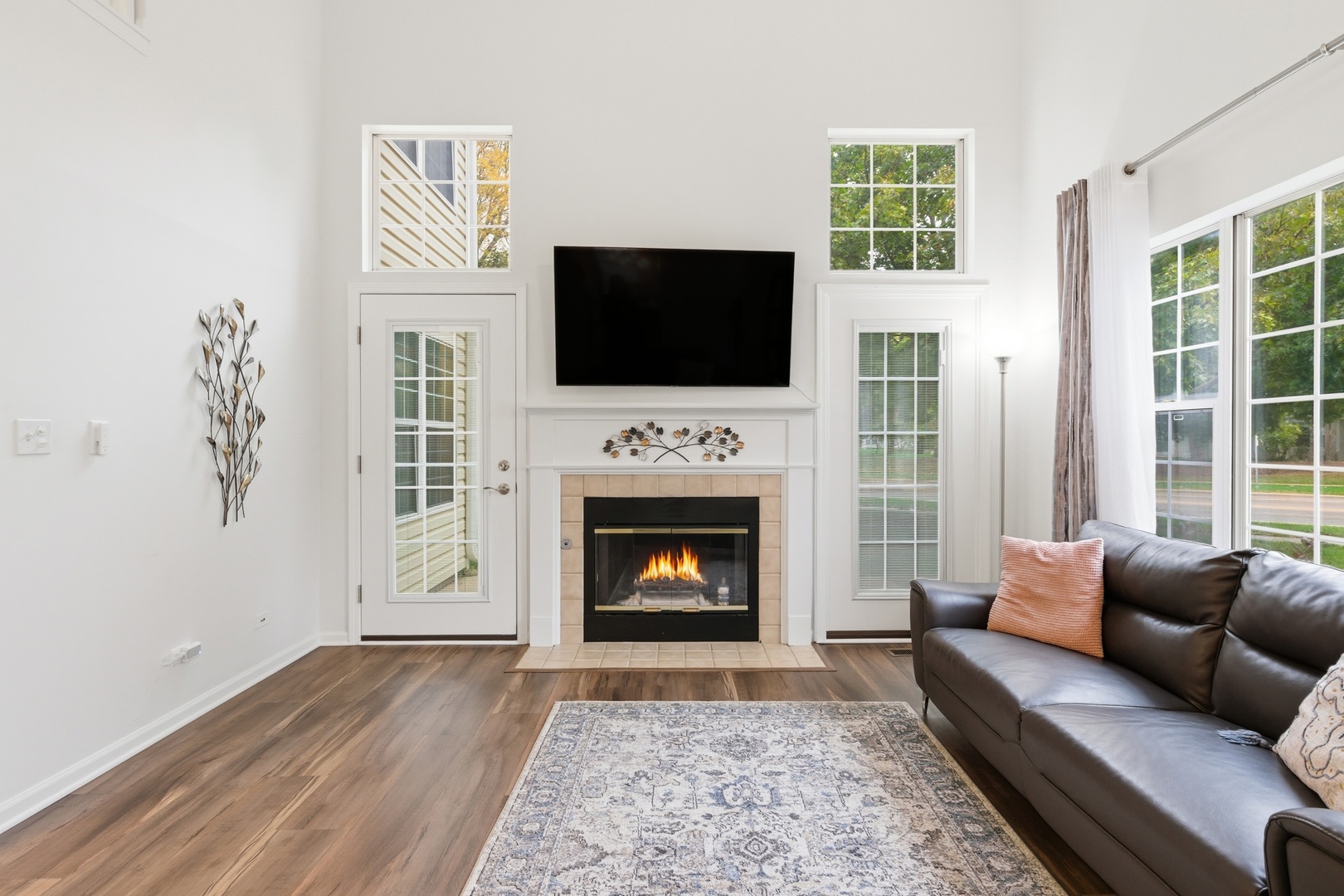 1411 Clybourne Street, Unit 11E Batavia, IL 60510 - Photo 7 of 34 a living room with furniture a flat screen tv and a fireplace