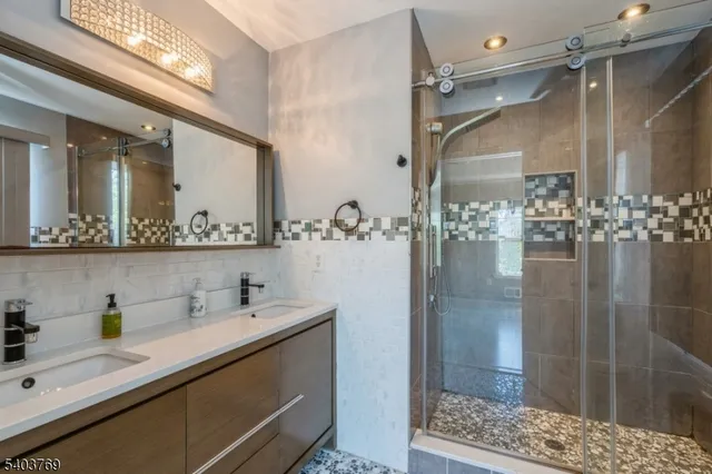 a bathroom with a double vanity sink mirror and shower