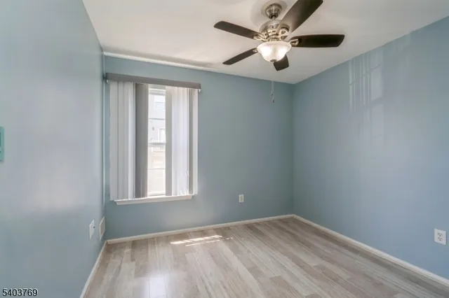 an empty room with a window and a fan