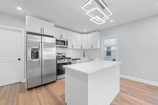 a kitchen with a sink stainless steel appliances a refrigerator and a stove top oven