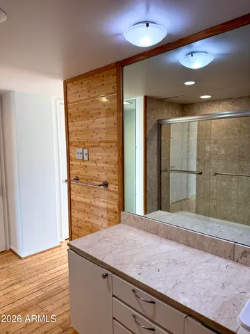 a bathroom with a granite countertop sink and a shower