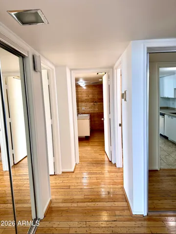 a view of a hallway view with wooden floor and living room