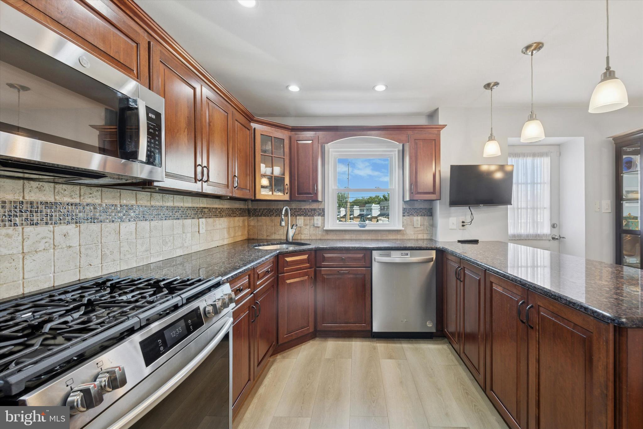 401 Haverford Road Folsom, PA 19033 - Photo 12 of 26 a kitchen with stainless steel appliances granite countertop a stove a sink and a microwave