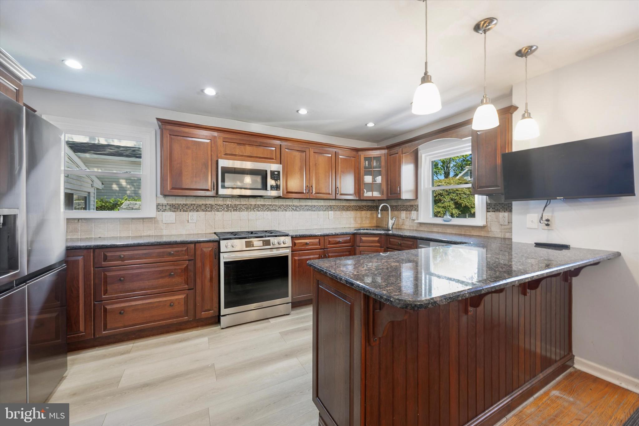 401 Haverford Road Folsom, PA 19033 - Photo 10 of 26 a kitchen with stainless steel appliances granite countertop a sink a stove and a refrigerator