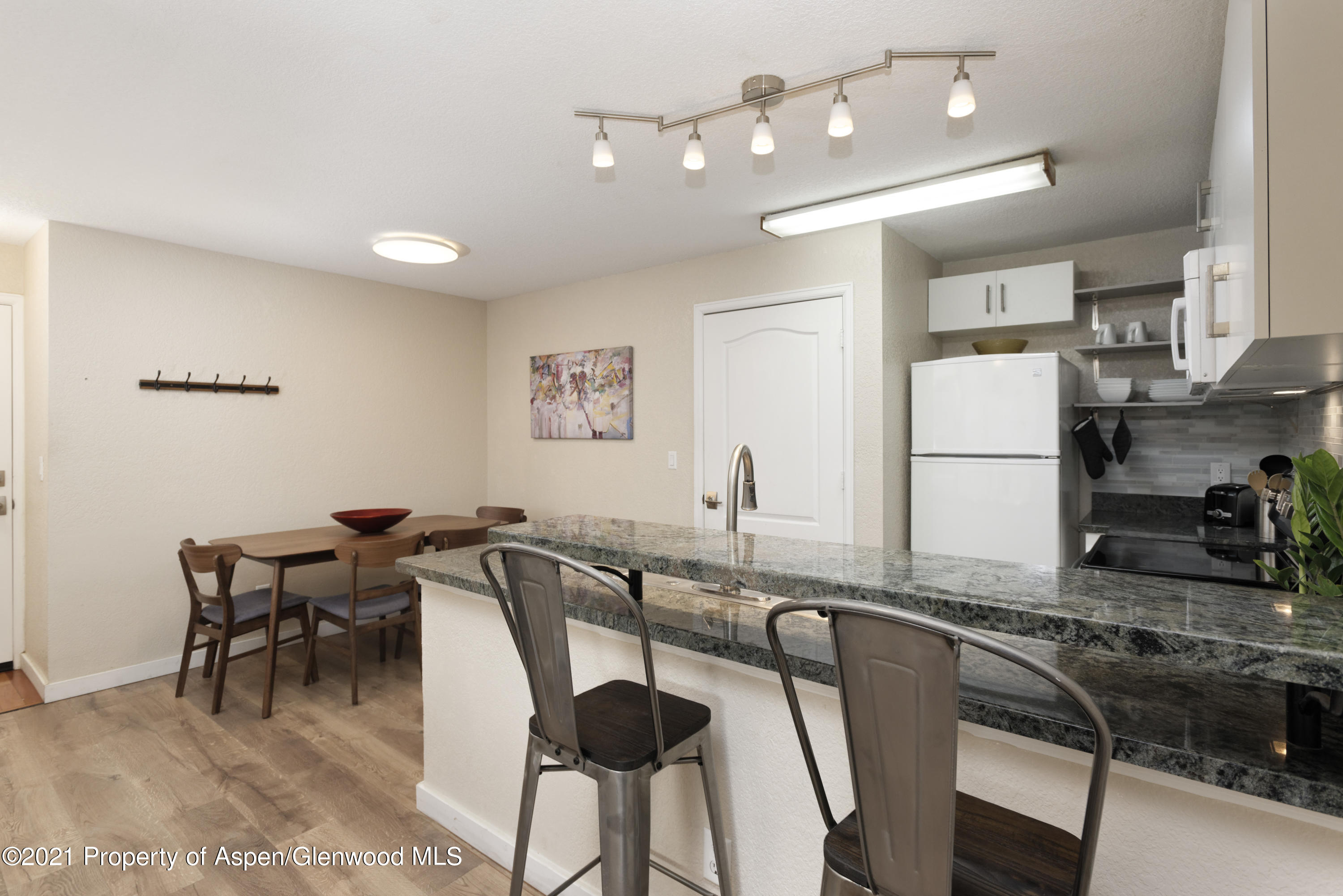 8104 Elk Lane Basalt, CO 81621 - Photo 4 of 13 a kitchen with stainless steel appliances granite countertop a dining table chairs and a refrigerator