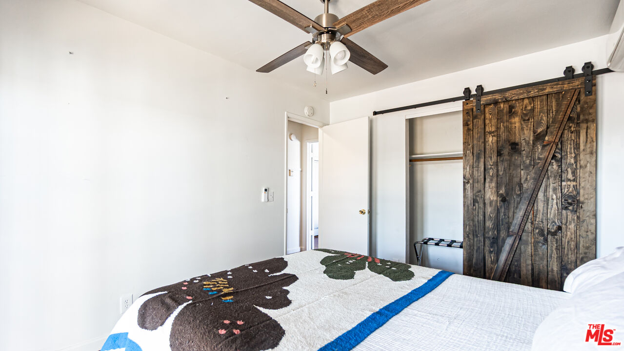 62033 Bonair Road Joshua Tree, CA 92252 - Photo 23 of 53 a bedroom with a bed and a chandelier