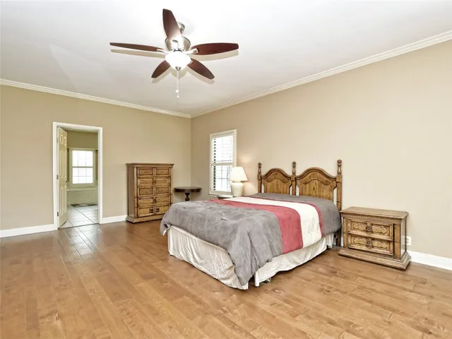 a spacious bedroom with a bed and a ceiling fan