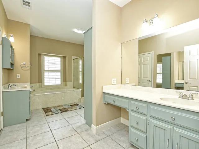 a spacious bathroom with a granite countertop sink a mirror and a bathtub