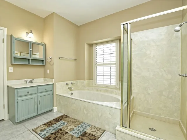 a bathroom with a tub sink shower and a mirror