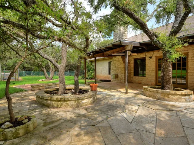 a front view of a house with a garden and trees