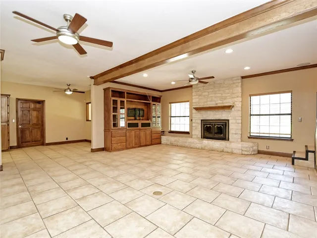a view of an empty room with a fireplace and a window