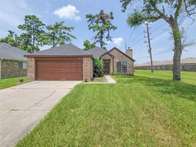 a view of a house with a yard and tree