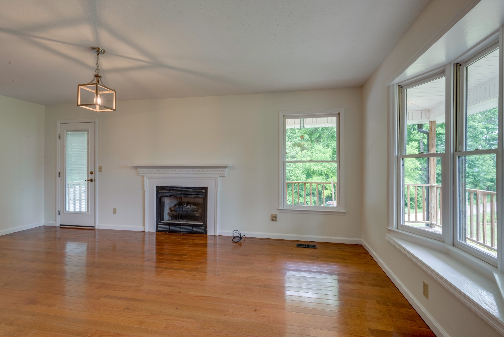146 Howard Road White Bluff, TN 37187 - Photo 5 of 25 an empty room with windows fireplace and wooden floor